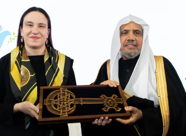 ‏عمدة سراييفو، السيدة بنيامينا كاريتش، تُسَلِّمُ معالي الأمين العام، الشيخ د.⁧‫محمد العيسى‬⁩ "مفتاحَ مدينة سراييفو"